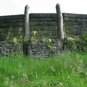 Wallanlage Nachbau Nachbau einer historischen Wallanlage aus Holz und Stein, umgeben von grüner Vegetation.