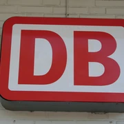Deutsche Bahn Rotes DB-Logo der Deutschen Bahn auf heller Ziegelwand montiert. Symbol für den Schienenverkehr.