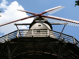 Mühle Eystrup Historische Mühle mit rot-weißen Flügeln und hölzernem Balkon vor blauem Himmel im Eystrup.