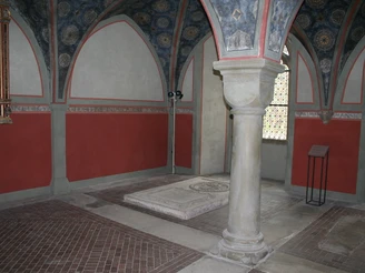 Seitenkapelle Historische Seitenkapelle mit gewölbter Decke und Säule, geschmückt durch Fresken und Mauerornamente.