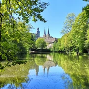 Blick auf die Abtei Marienmünster Abtei Marienmünster mit ihren markanten Türmen spiegelt sich in einem stillen, umgebenen Teich.