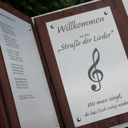 Marklohe Straße der Lieder Willkommensschild der "Straße der Lieder" mit Notenschlüssel und Gedicht, inspiriert zum Mitsingen.