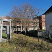 WC Parkhaus am Hafen Öffentliche Toilette im Parkhaus nahe dem Hafen, umgeben von Bäumen und Gebäuden in urbanem Umfeld.