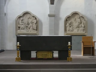 Altar der Gaukirche, geschmückt mit einem Reliquienschrein, flankiert von kunstvollen Reliefs.