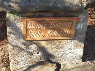 Der Kleine Herrgott hat ein neues Schild erhalten. Steinmonument im Wald, mit neuem Schild "Kleiner Herrgott, Sächs. Kultstätte" versehen.