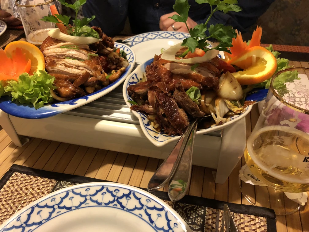 Asiatisches Gericht Ein buntes, reichhaltiges asiatisches Gericht mit knusprigem Fleisch, frischem Gemüse und Zitrusdeko.