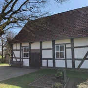 Kapelle Röhden Schlüsselburg Schlichte Fachwerkkapelle mit hellem Anstrich und roten Dachziegeln, umgeben von grüner Natur.