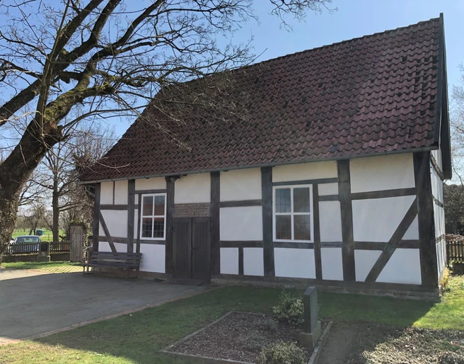 Kapelle Röhden Schlüsselburg Schlichte Fachwerkkapelle mit hellem Anstrich und roten Dachziegeln, umgeben von grüner Natur.