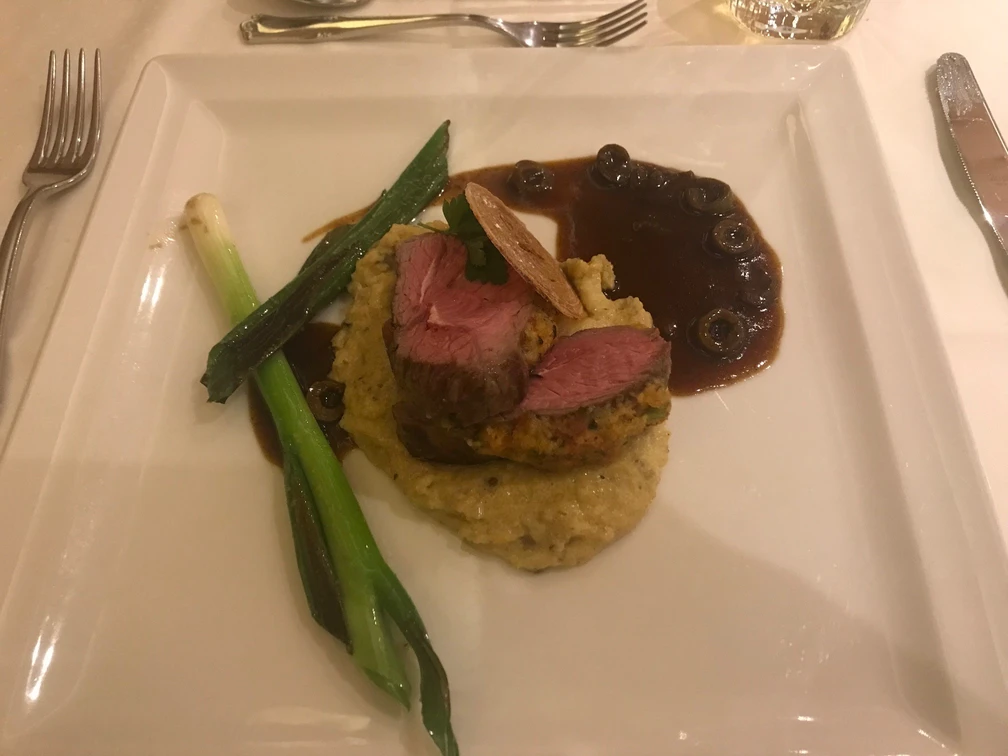Hauptgericht Zartes rosa Rinderfilet auf Kartoffelpüree, dekoriert mit Lauch und würziger Pilzsoße.