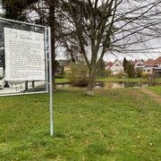 Park der 3 Teiche direkt neben dem Alten Kurpark Bad Rehburg Park mit drei Teichen, umgeben von Grünflächen und Wohnhäusern, Informationstafel im Vordergrund.