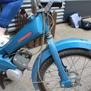 Mofa-Helden Ein blauer Zündapp-Mofa mit Reifenprofil, auf dem eine Person mit weißen Sneakern sitzt.