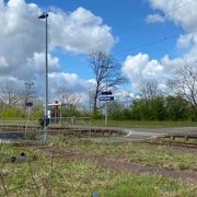 Bahnhof Leese-Stolzenau vor blühenden Bäumen und blauem Himmel; ruhig gelegen mit Bahnsteigzugang.