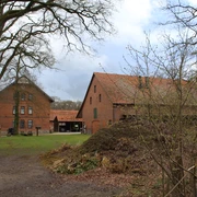 Rittergut Varste Backsteingebäude des Rittergut Varste mit Satteldach, umgeben von Bäumen und einem winterlichen Weg.