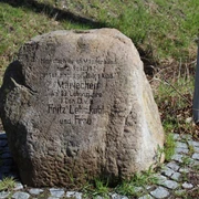 Gedenkstein Mariechen Lehmkuhl Gedenkstein zu Ehren von Mariechen Lehmkuhl, umgeben von Pflastersteinen auf grasbewachsenem Untergrund.