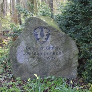 Gedenkstein Grafenburg Wietzen Gedenkstein aus Stein mit Inschrift "Burgen der Grafen de Stumpenhus 1975 - 1977" in einer grünen Waldszene.