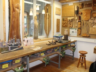 KreativWerkstatt am Wall Holzwerkstatt mit Werkbank, Werkzeugen und hölzernen Kunstwerken an den Wänden, inklusive Modellbau.