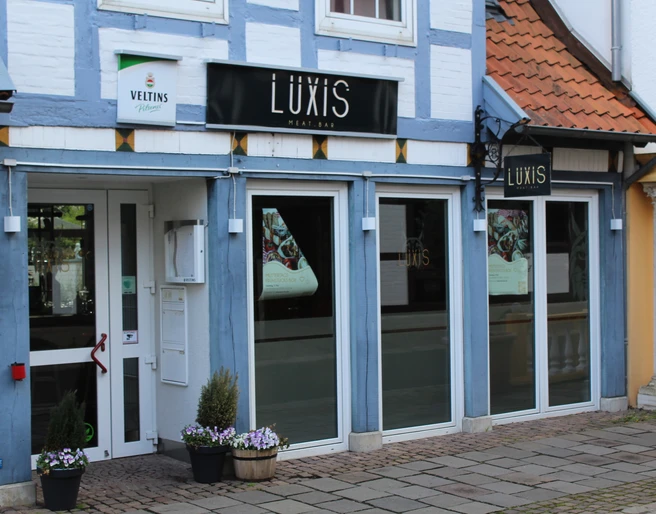 Luxis Meatbar Luxis Meatbar in einem Fachwerkhaus, mit blauen Holzbalken und einladenden, großen Fenstern.