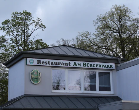Restaurant am Bürgerpark Restaurant am Bürgerpark mit großer Fensterfront und grünen Bäumen im Hintergrund.