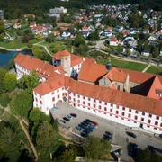 Schloss Iburg aus der Vogelperspektive Luftaufnahme eines historischen Schlosses mit rotem Dach, umgeben von Wohnhäusern und Grünflächen.