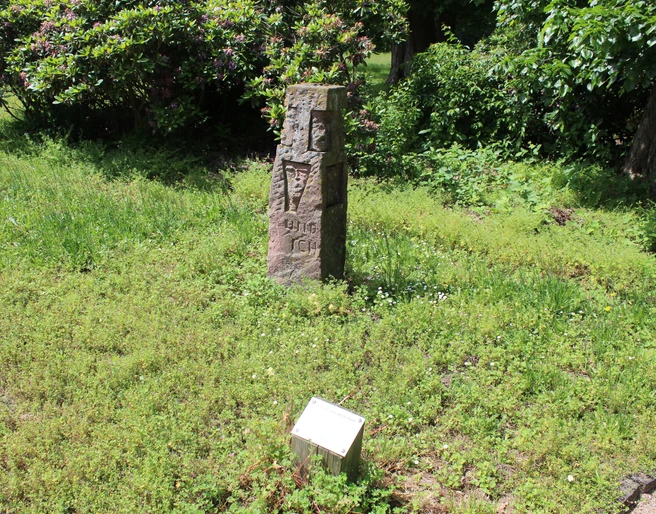 Skulptur im Park Etelsen "und ich war auch hier" Steinmonument im Grünen mit Inschrift "und ich war auch hier", umgeben von Pflanzen im Park Etelsen.