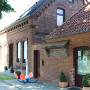 Dobberschütz Nienburg Traditionelles Klinkergebäude mit Anker als Dekoration vor der Tür, umgeben von grünen Sträuchern.