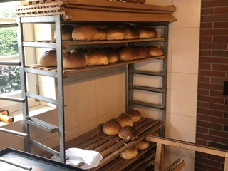 Stuten in Reih und Glied Frisch gebackene Laibe Stuten auf einem drei Ebenen hohen Holzregal