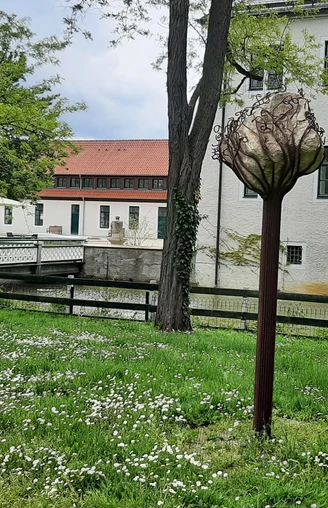 Schloss Benkhausen Skulptur im Park des Schlosses Benkhausen, umgeben von grüner Wiese und blühenden Bäumen.
