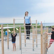 Mehrere sportlich gekleidete Personen machen Sport auf dem Outdoor-Bewegungsparcours vor der Nordsee. Several athletically dressed people are exercising on the outdoor exercise trail in front of the North Sea.