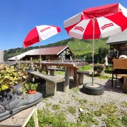 Berghaus Grimmi terrace Rotweisse Sonnenschirme, Tische und Bänke auf der BerghausterrasseRed and white parasols, tables and benches on the Berghaus terraceParasols rouges et blancs, tables et bancs sur la terrasse du Berghaus