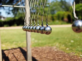 Klangelemente im Kurpark in Bad Laer Kunstinstallation mit mehreren schwingenden Metallkugeln im Freien auf Rasenfläche.