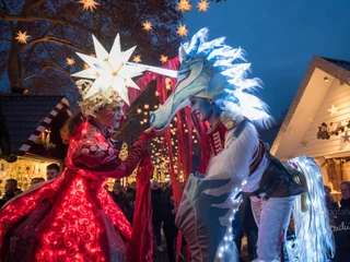 Market of Angels in Cologne Eine farbenfrohe Szene auf dem "Markt der Engel": Zwei Künstler in prachtvollen Kostümen unter leuchtenden Sternen.A colorful scene at the "Market of Angels": Two artists in magnificent costumes under shining stars.