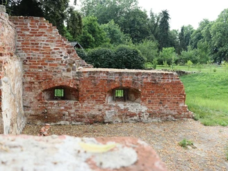 Ellerburg Ziegelruinen einer mittelalterlichen Burgmauer mit zwei Fensteröffnungen, umgeben von grüner Landschaft.