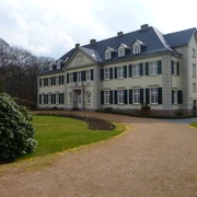 Schloss Laach Schloss Laach, ein beigefarbenes Herrenhaus, steht inmitten eines gepflegten Parks mit geschwungenen Wegen.