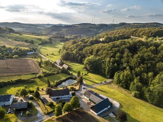 Weitblick in der Elfringhauser Schweiz Landschaft der Elfringhauser Schweiz mit sanften Hügeln, Wäldern und vereinzelten Gebäuden unter blauem Himmel.
