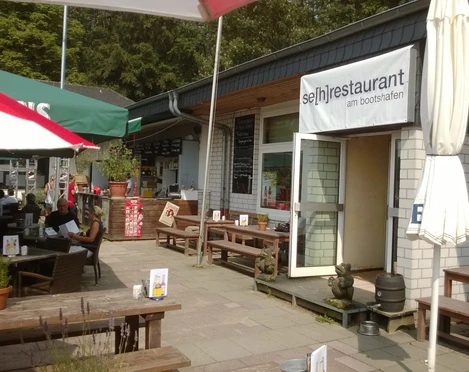 Se(h)-Restaurant Unterbacher See Das Se(h)-Restaurant am Unterbacher See bietet Sitzgelegenheiten und eine Außenansicht des Gebäudes.