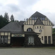 Historisches Gebäude mit Fachwerkfassade und Turm, genannt Alter Bahnhof. Uhr und Eingang erkennbar.