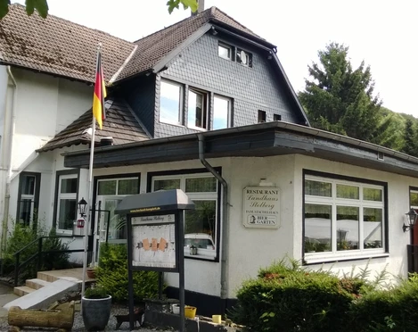 Landhaus Stolberg Restaurant Landhaus Stolberg mit deutscher Flagge, umgeben von grünen Bäumen und Waldsicht.