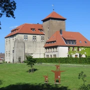 Burg Horn Burg Horn thront majestätisch auf einer Wiese mit rotem Ziegeldach und Umgeben von grünen Bäumen.