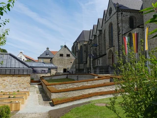 Kaiserpfalz in Paderborn mit romanischer Bartholomäuskapelle, umgeben von gepflegten Grünflächen.
