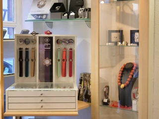 Bunte Uhrenarmbänder und eine Vitrine mit Schmuck