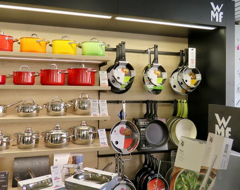 Pfannen und bunte Töpfe an einer Wand