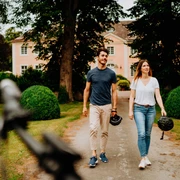 Teutoburger Wald-Brakel-Schloss Rheder ┬® Teutoburger Wald Tourismus (20).jpg Ein Paar spaziert vor Schloss Rheder, umgeben von gepflegten Hecken und üppigem Grün.