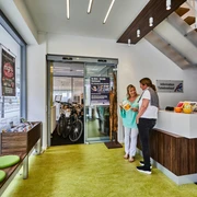 Tourist-Info Rheda-Wiedenbrück Zwei Frauen im modernen Tourist-Info-Büro mit Broschüren und mobilen Fahrrad-Verleihmöglichkeiten.