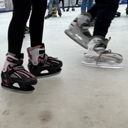 Schlittschuhe Schlittschuhläufer mit pinken und grauen Schlittschuhen gleiten über eine Eisbahn.