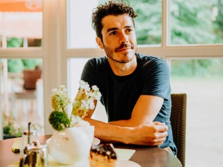 Teutoburger Wald-Brakel-Kurpark Cafe ┬® Teutoburger Wald Tourismus (1).jpg Ein Besucher im Kurpark Café Brakel genießt ein Stück Kuchen bei entspanntem Ambiente am Tisch.