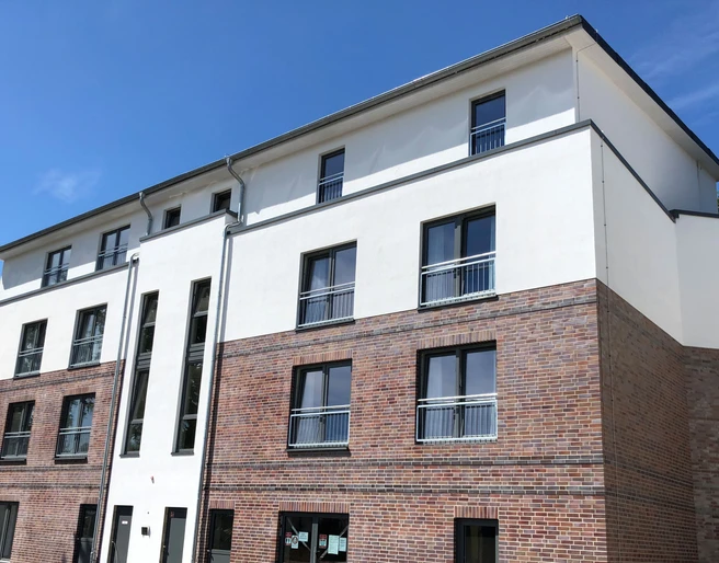 Moderne Wohnanlage mit klaren Linien, blauem Himmel und mehreren Etagen in Nienburg an der Weser.