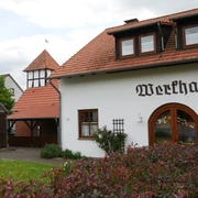 Werkhaus in Brakel-Bellersen Ein traditionelles Fachwerkhaus mit roten Dachziegeln und typischer Beschriftung in ruhiger Umgebung.