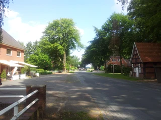 Das Landhaus Wachendorf liegt am Straßenrand, umgeben von Bäumen und traditionellen Backsteingebäuden.