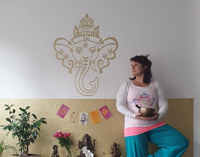 Jeder kann Yoga in Mölln Eine Frau steht in Yogastellung und hält eine Klangschale in den Händen