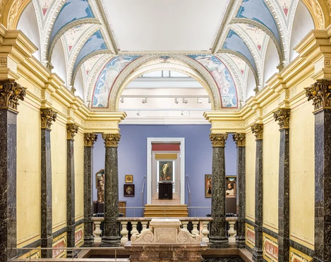 Ein Museumsraum mit kunstvoll gestalteten und gewölbten Decken und mit Gold verzierten Säulen aus schwarzem Marmor..